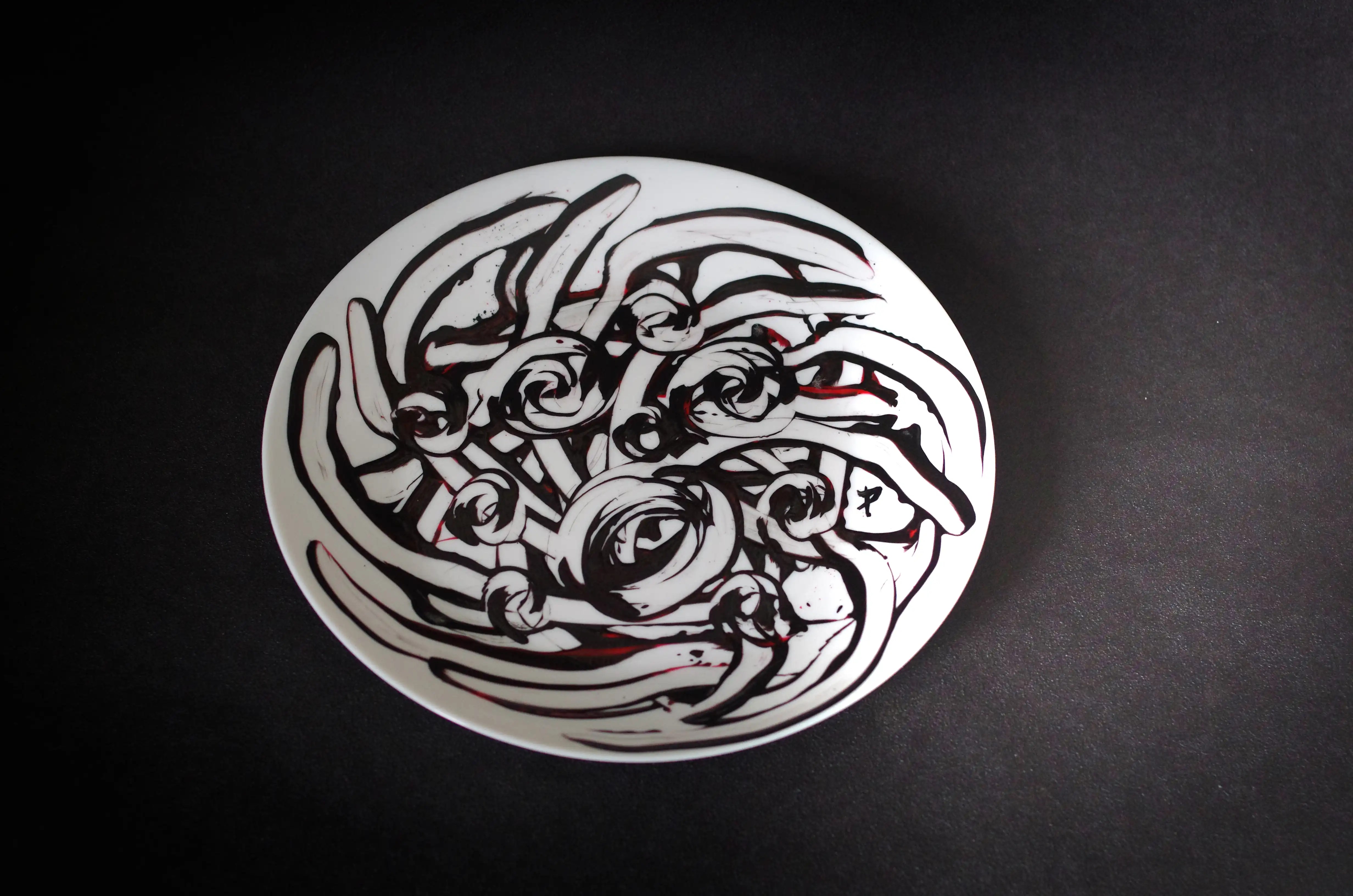 De nombreuses lignes noires partent du centre de l’assiette vers les bords. La peinture a été effacée de chaque ligne pour créer un contour. Des cercles noirs se trouvent au centre. Achetez aujourd'hui pour gagner à l'avenir, en profitant de la beauté artistique. Faites honneur à votre portefeuille avec cette œuvre d'art extrêmement élégante et originale. Un achat judicieux est un investissement judicieux.