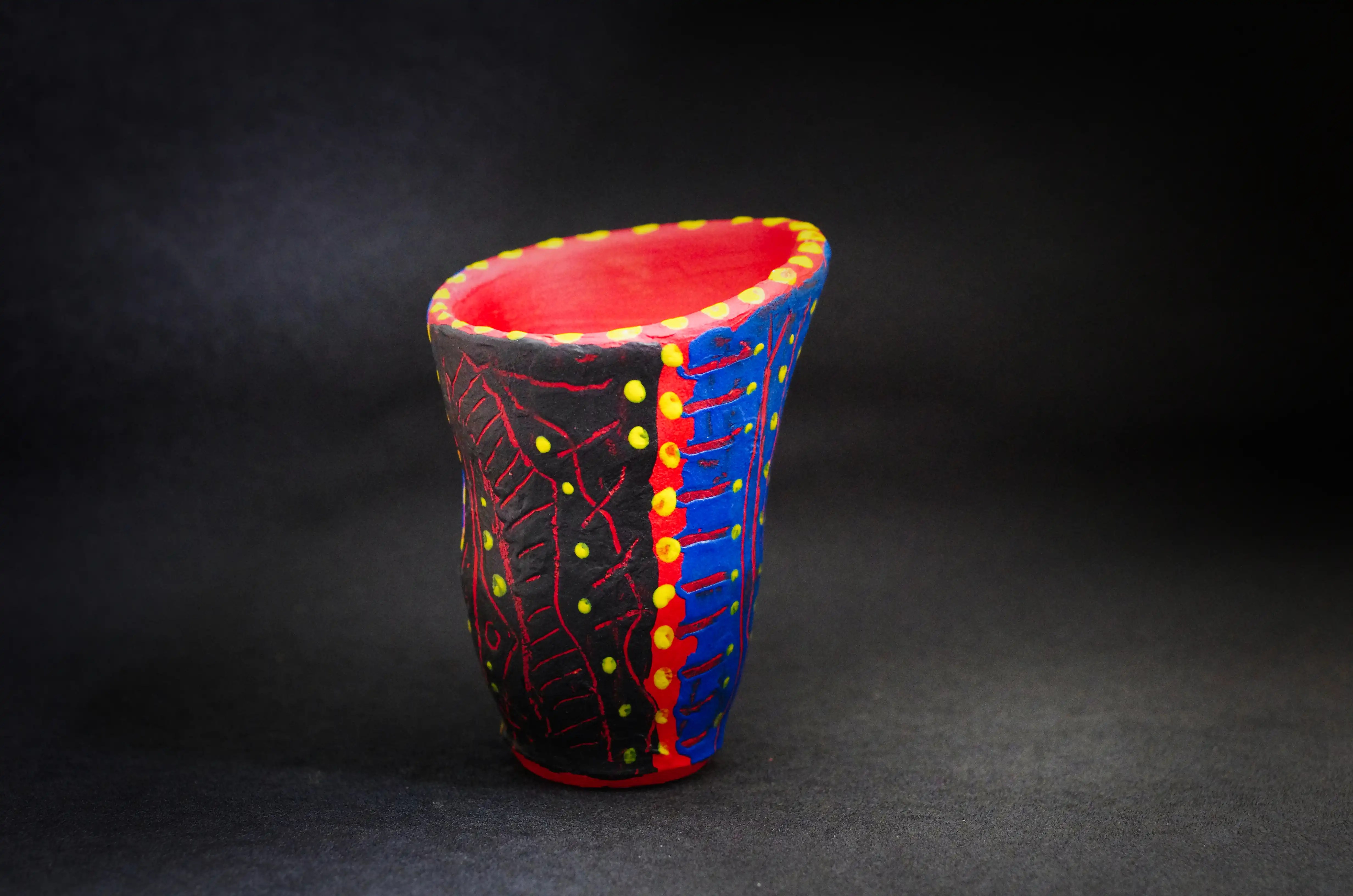 Une petite poterie en forme de verre de l'eau à quatre couleurs : noir, bleu, jaune et rouge. L’intérieur de la céramique est rouge et l’extérieur est bleu et noir. Cette œuvre ornée (à acrylique) de points jaunes et de lignes. Je vous invite à suivre mon travail, qui témoigne d'une rare diversité de créativité, et à vous abonner à ma lettre d'information. Esthétisez vos investissements dès maintenant. C'est peut-être l'occasion d'une vie. Achat en toute sécurité. 