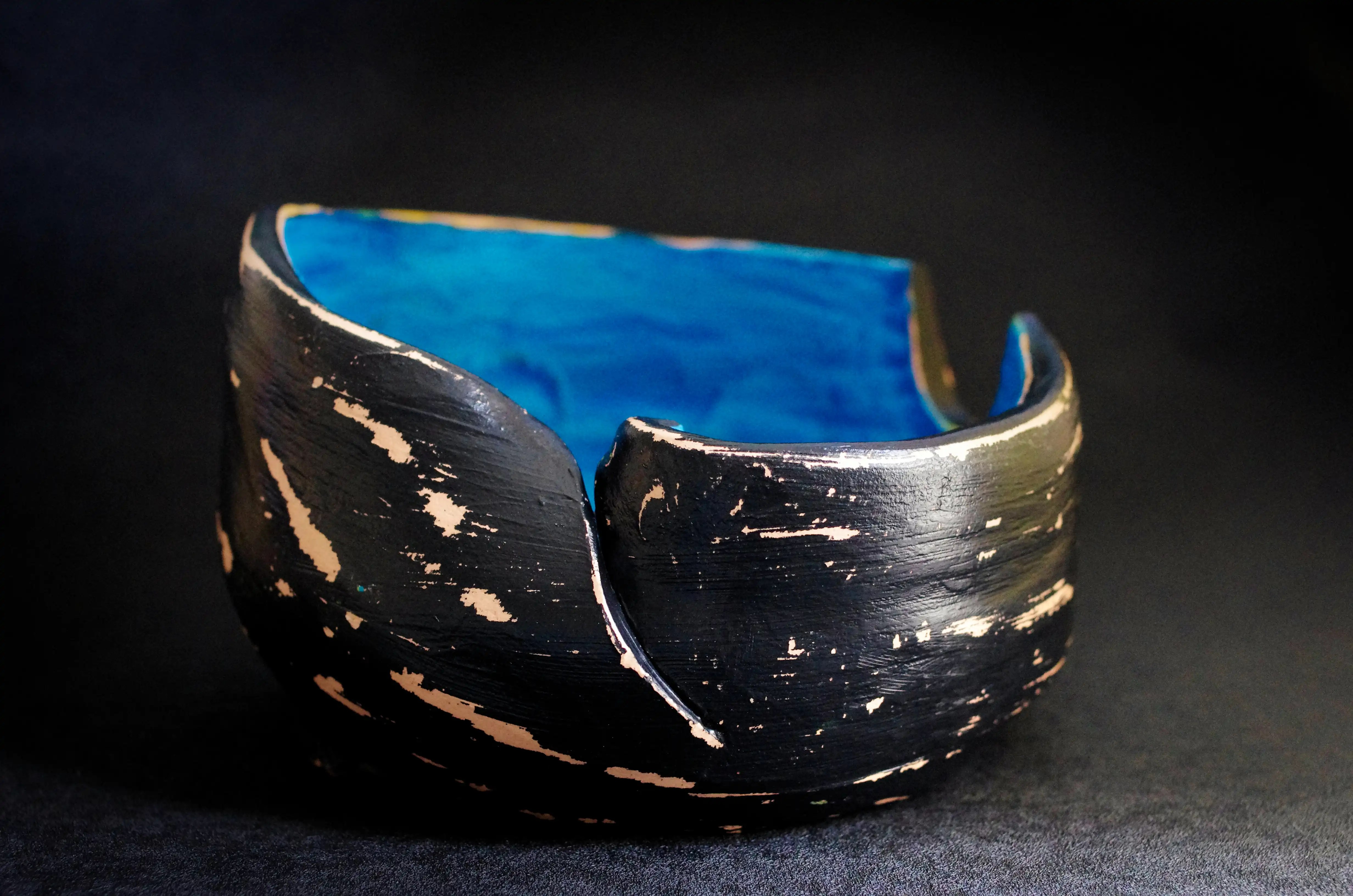 D'un côté, il y a une cavité semi-circulaire d'un diamètre de 6 centimètres, l'autre côté est coupé verticalement et l'une des deux extrémités est incurvée vers l'intérieur. L’intérieur de cette poterie est bleu et extérieur est noir légèrement gratté. Valorisez vos investissements avec des œuvres d'art de qualité. Achat en toute sécurité. Enrichissez vos investissements et exposez fièrement votre collection avec mes œuvres d'art abstraites | brutes | originales et de qualité.